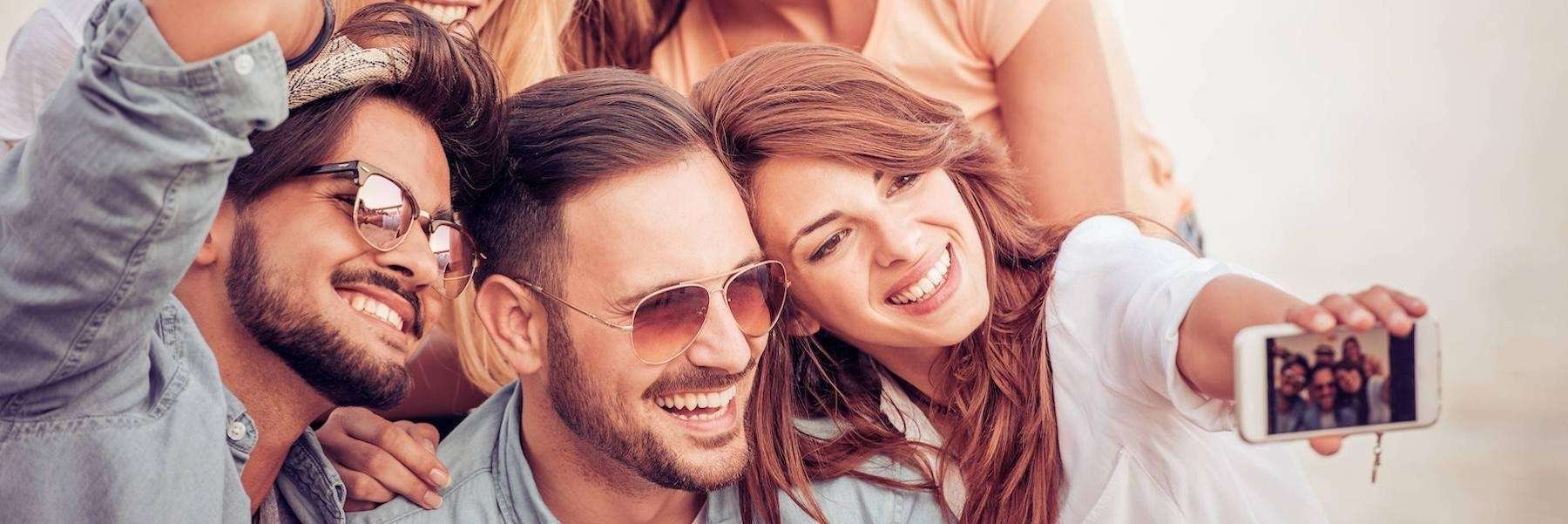 A group of smiling friends taking a selfie | cosmetic dentistry Vancouver BC