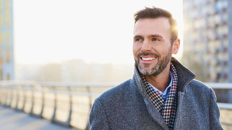 A smiling man on a bridge | Vancouver dentist