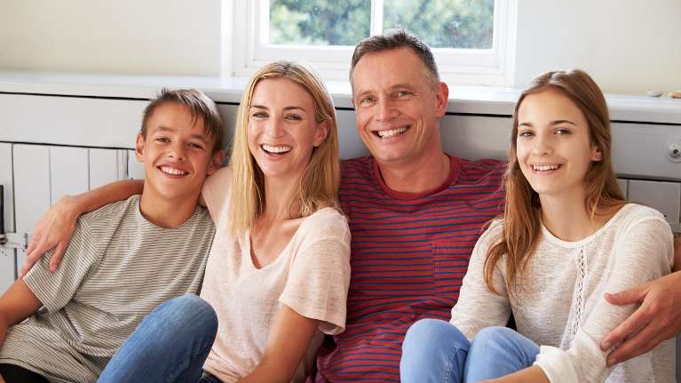 son, mother, father, and daughter smiling