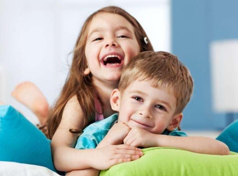 young sister and brother smiling