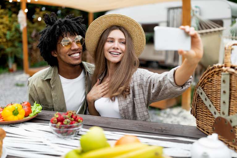 A couple taking selfies at brunch