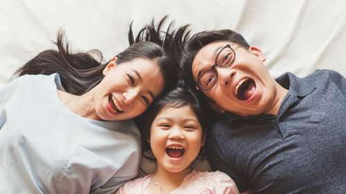 mom, dad, and daughter laughing 