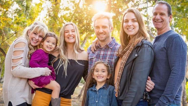 A smiling family picture in the forest | dentist Vancouver