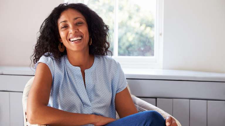 A smiling woman by the window 