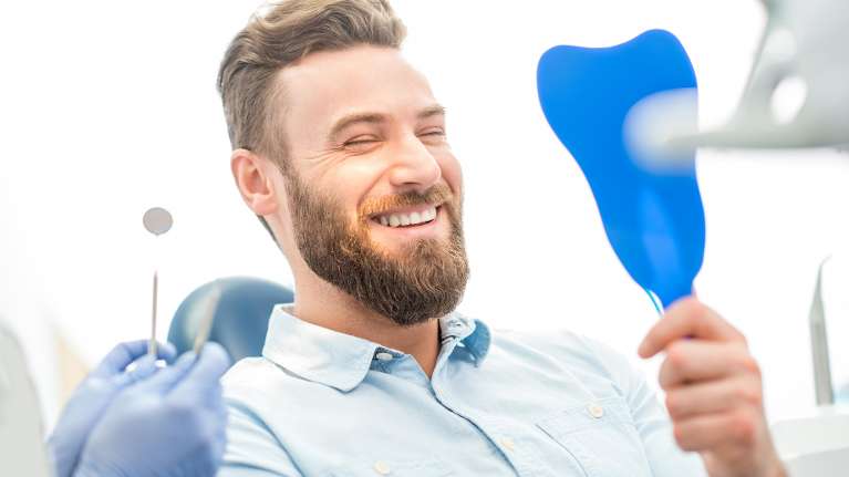 A man examining his dental implants