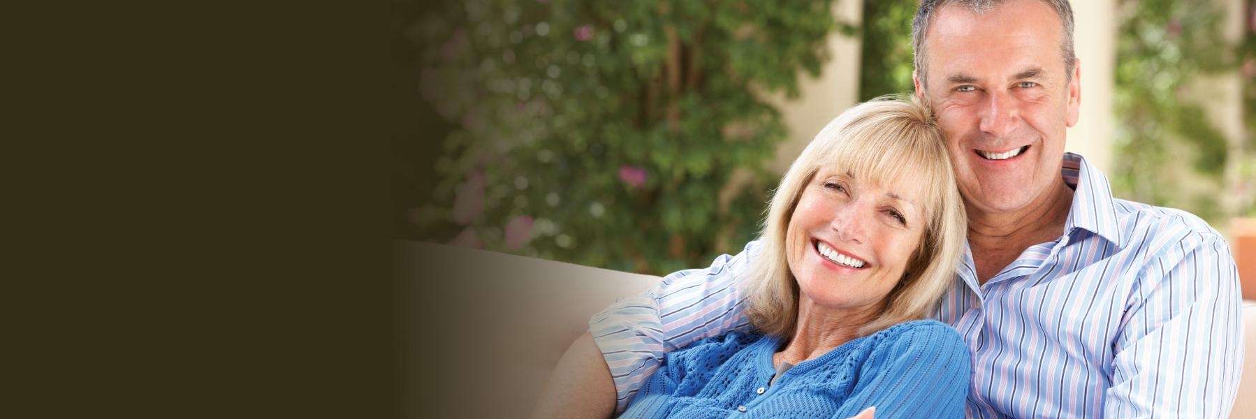 A couple smiling on the couch | Vancouver dentist