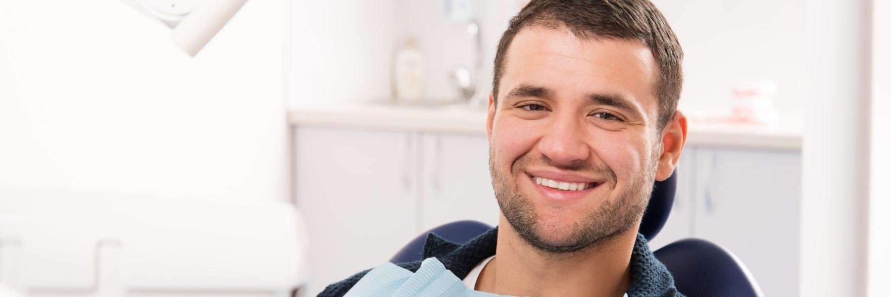 A smiling man in the dentist's examination chair