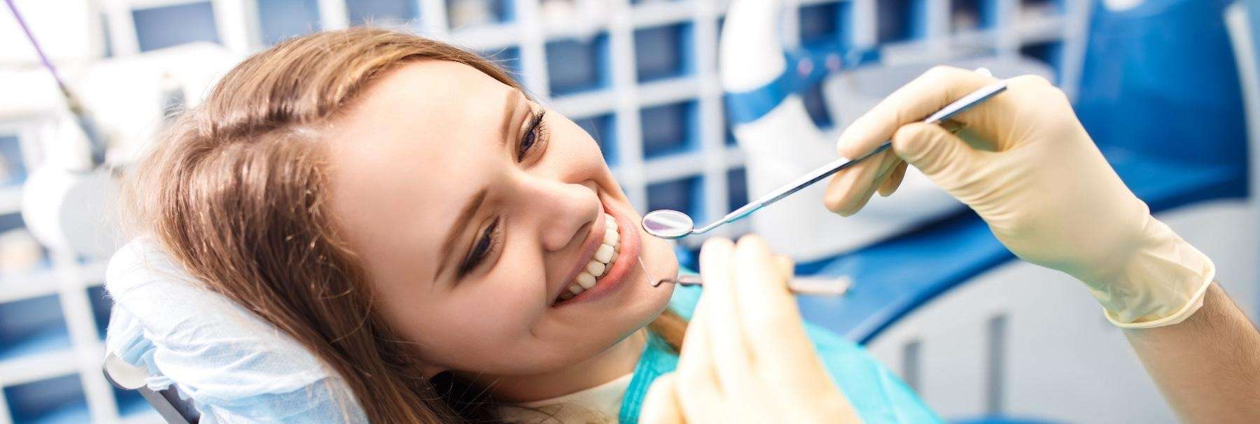A smiling woman receiving a dental examination