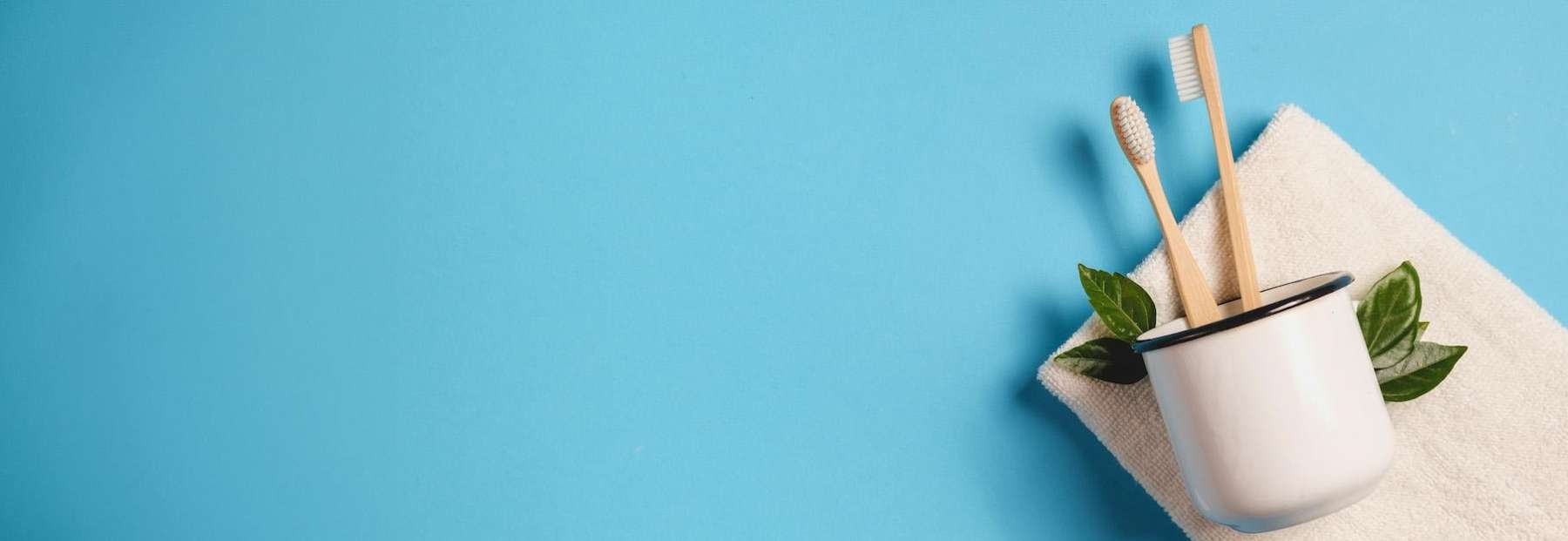 two wooden toothbrushes in a cup